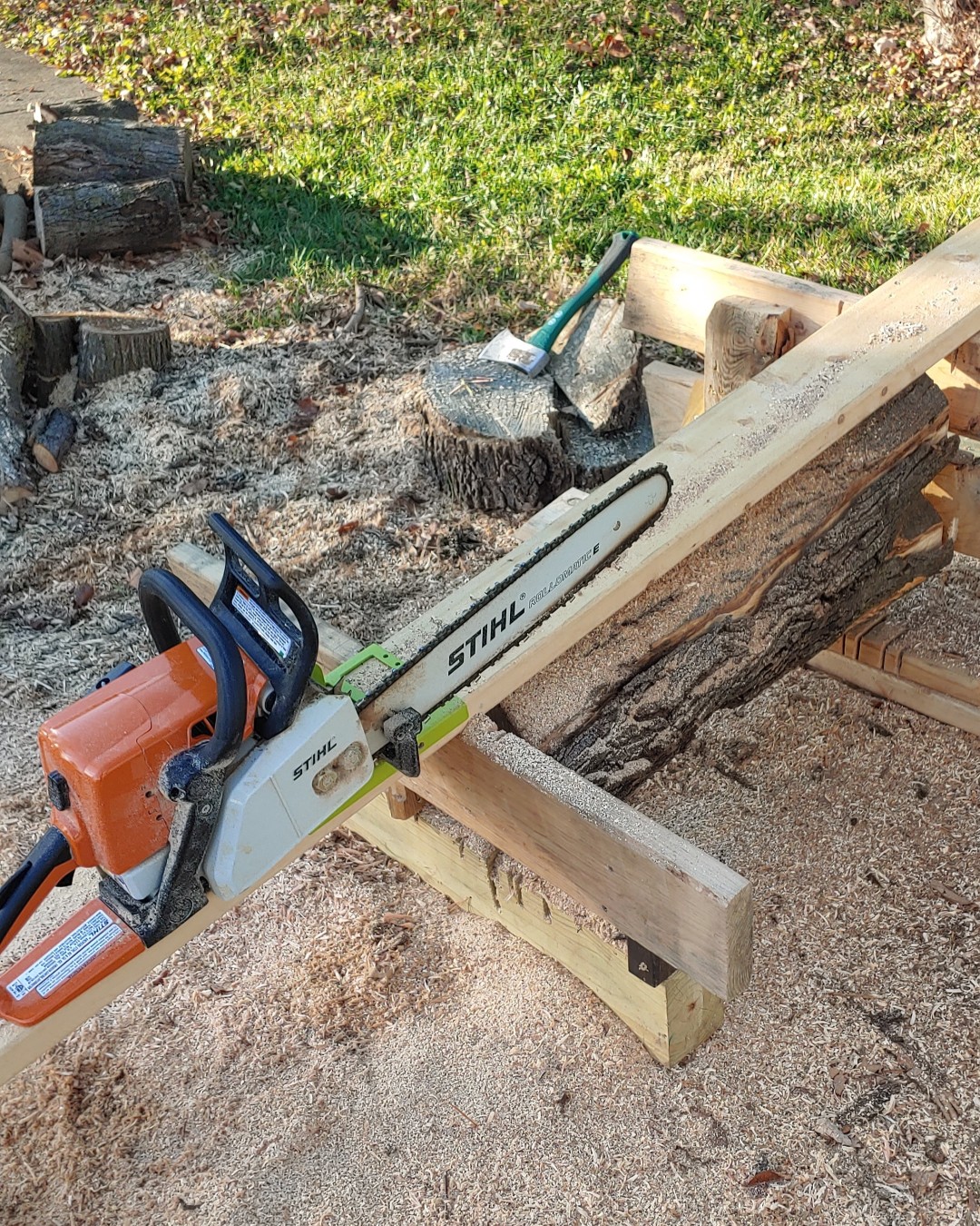 Chainsaw with jig on 2x6 and small log