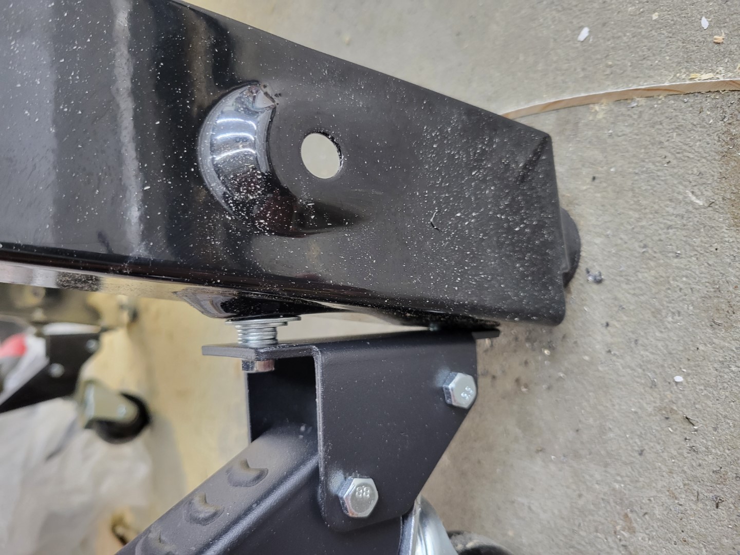 Side profile of caster wheels mounted to table saw legs with washers